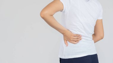 Şiddetli bel ağrısı olan ve ellerini beyaz arka plan tıbbi konseptiyle kaplayan bir kadın..