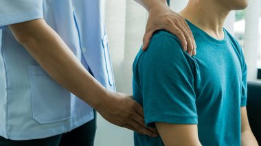 Omzu ağrıyan ve masaj yapan bir adam. Tıbbi konsept. Sağlık ve fizik tedavi.