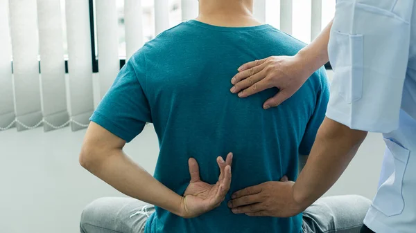 Man with back pain and a doctor giving massage medical concept Health care and physical therapy
