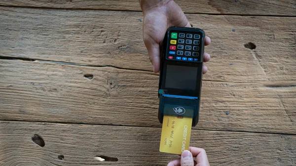 card swipe machine In the shop of payment buys and sells goods and services. Credit card swipe machine on a wooden table.