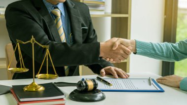 Avukatlar iş yerindeki müşterilerle el sıkışıyor. Hakimin çekiçleri ve altın pullarıyla. Hukuki Konseptler ve Danışmanlar