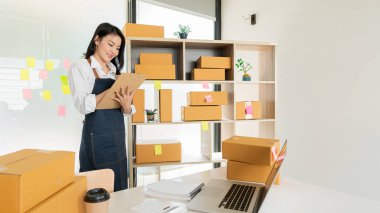 Ev Kutusu Smartphone Laptop Çevrimiçi Pazarlama Paket Taşıma Konsepti E-ticaret kavramından çalışan Asyalı genç kadının küçük işletme KOBİ Serbest Çalışan Portresi