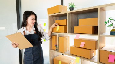 Ev Kutusu Smartphone Laptop Çevrimiçi Pazarlama Paket Taşıma Konsepti E-ticaret kavramından çalışan Asyalı genç kadının küçük işletme KOBİ Serbest Çalışan Portresi