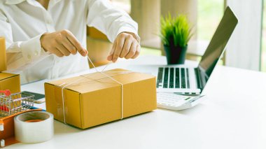 Asyalı küçük işletme girişimcisi KME evde dizüstü bilgisayar kutusu ile çalışıyor Dijital teknoloji kavramı, KME, e-ticaret, KOBİ, dağıtım