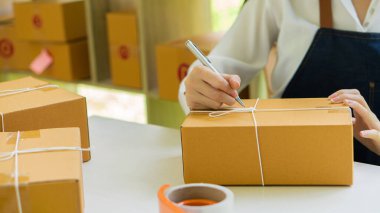 Asyalı küçük işletme girişimcisi KME evde dizüstü bilgisayar kutusu ile çalışıyor Dijital teknoloji kavramı, KME, e-ticaret, KOBİ, dağıtım