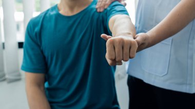 Bedeninde acı çeken genç bir adam ve fizyoterapi ve ilaç tedavisine yardımcı olan bir doktor..