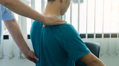 Bedeninde acı çeken genç bir adam ve fizyoterapi ve ilaç tedavisine yardımcı olan bir doktor..