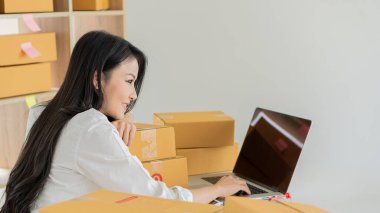 Asyalı Girişimci Küçük işletme kurmak, KOBİ bağımsız, evde çalışan, yerde ve dizüstü bilgisayarında kutular, pazarlama, paketleme, ulaşım, KOBİ, e-ticaret kavramı