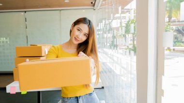 Asyalı Girişimci Küçük işletme kurmak, KOBİ bağımsız, evde çalışan, yerde ve dizüstü bilgisayarında kutular, pazarlama, paketleme, ulaşım, KOBİ, e-ticaret kavramı