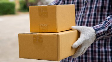 Teslimatçı beyaz eldivenli bir karton kutu taşıyordu ve teslimat hızlı ve bedavaydı. Çevrimiçi alışveriş ve hızlı teslimat