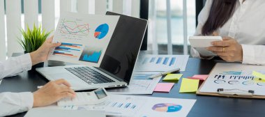 Ofiste çalışan bir iş adamı. Bilgisayarı ve hesap makinesi olan bir masa grafik veri tablosu. Hesaplamak ve analiz etmek için..