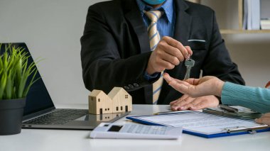 Satıcı ev satın alma sözleşmesi teklif eder veya kredi ve faiz oranlarını tartışır. Yeni ev sahipleri arasında bir ev alırken veya masa, çalışma alanı, ev satın alma ve kiralama fikirleri arasında.