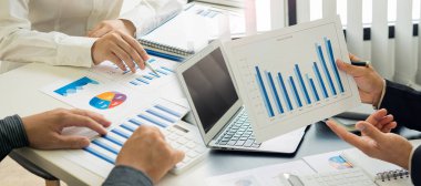 Finansal grafiği olan bilgisayar ve hesap makinesi kullanan kadın muhasebeci ve en üst görünüm masasındaki ev ofis giderlerini hesapla.