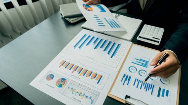 Finansal grafiği olan bilgisayar ve hesap makinesi kullanan kadın muhasebeci ve en üst görünüm masasındaki ev ofis giderlerini hesapla.