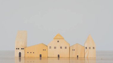 Gri arka plan masasında çeşitli küçük ahşap evler