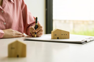 İş adamı ya da ev satış temsilcisi sözleşme belgeleri ve dizüstü bilgisayarlı hesap makineleriyle çalışıyor. Gayrimenkul yatırımları ve ev alımları için faiz, vergi ve kârın hesaplanması.