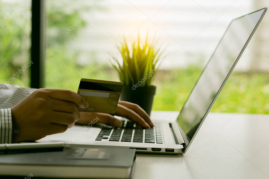 young woman holding credit card and using a laptop computer work at home and online shopping, e-commerce, internet banking,