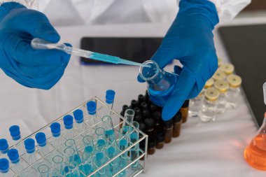 Modern laboratuvar bilimcileri bir deney yürüterek elindeki şişede bir bileşik sentezlediler. Bilim adamları aşıları COVID-19 'a karşı test ediyorlar..
