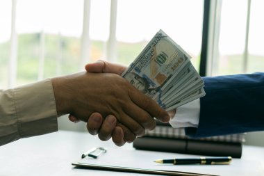 İki işadamı, liberalleşme yolsuzlukla uğraştıktan sonra ellerinde büyük paralarla el sıkışıyor..