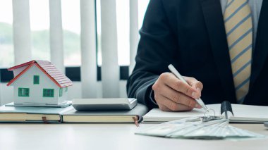 Satış temsilcileri resepsiyonda ev satın alma sözleşmeleri veya ofis kredileri ve faiz oranlarıyla çalışırlar.