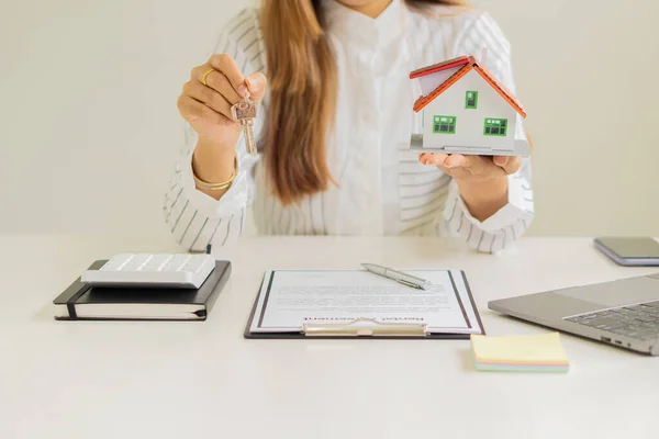 Sales representatives work at the desk with home purchase contracts or on office loans and interest rates.