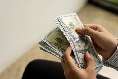 İş adamlarının elleri, Amerikan dolarının yakın planında dolarları sayıyor. Nakit. Ödeme konsepti.