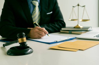 Avukatlık bürosu yargıcı çekiçle ve dizüstü bilgisayarlı teraziyle takım elbiseli bir işadamı ya da evrak işleriyle uğraşan bir avukat. Hukuk, Rehberlik ve Adalet Kavramları