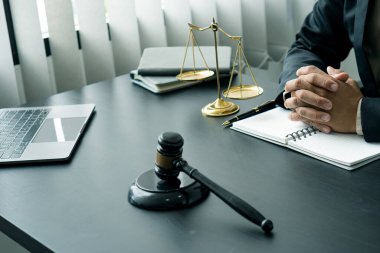 Avukatlık bürosu yargıcı çekiçle ve dizüstü bilgisayarlı teraziyle takım elbiseli bir işadamı ya da evrak işleriyle uğraşan bir avukat. Hukuk, Rehberlik ve Adalet Kavramları