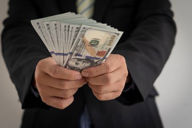 İş adamı elinde para sayıyor. Dolarların yakın plan hesabı, finansal iş konsepti..