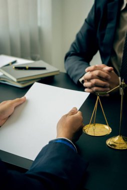 Avukatlar sözleşme belgelerini tartışırlar. Fikirlerin ve hukuki tavsiyelerin olduğu bir masada oturmak. Hukuki hizmetler İşadamı ve erkek avukat ya da hakim portre resimleri olan müvekkil ekibine danıştı.