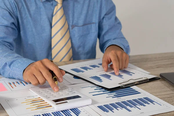 Businessman holding a pen pointing to an analysis graph, investment planning, work projects and business discussion strategies.