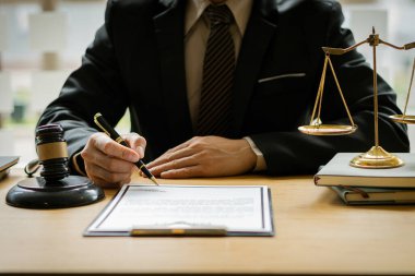 Yargıç ve savcının takım elbiseli çekiç işadamı evrak, hukuk, tavsiye ve adalet konseptlerinde dizüstü bilgisayar, çekiç ve femida ile çalışıyor..