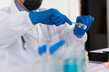 Tıp laboratuarında çalışan profesyonel bir sağlık araştırmacısı. Hastane için Tıbbi Deneyler Laboratuvarı Cam Sıvıları içeren Deneysel Kimya Teknolojisi