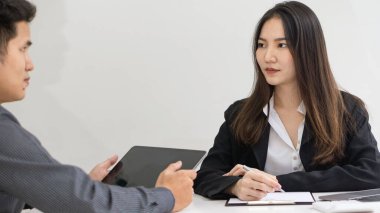 Bir iş kadını, modern bir ofiste yeni bir projeyi meslektaşlarına açıklar. Bir kadın ve iki erkek ofiste bir masanın üzerinde otururken belgeleri analiz ediyorlar. Ofiste çalışan kadın yöneticiler belgeleri tartışıyorlar.