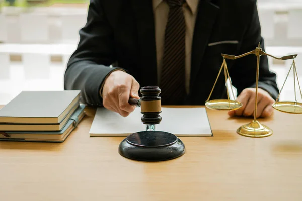 木製のテーブルの上の法廷で男性裁判官とオフィスで働くカウンセラーや弁護士 ノート 正義の概念を持つ黄金のハンマーとスケールの法律 — ストック写真