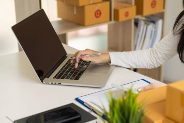 Küçük işletme girişimi KOBİ Kadın Girişimciler Bilgisayarınızda online siparişleri kontrol edin. KOBİ müşterilerine satılacak kutuları çevrimiçi iş fikirlerine hazırlamak için