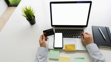 İşadamı internetten alışveriş yapmak ve kredi kartıyla alışveriş yapmak için beyaz ekranlı dizüstü bilgisayar kullanıyor. ev çevrimiçi alışveriş fikirleri
