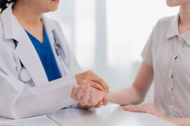 Kıdemli bayan doktor hasta genç kadını muayene ediyor. Kıdemli doktor bayan hastayı ziyaret edip muayene ediyor. Sağlık hizmetleri kavramı.