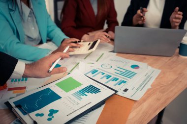 Stratejik planlama için dizüstü bilgisayarlar ve dijital çizelgeler kullanarak iş ekibiyle veri analiz toplantısı. Ofiste çalışan dijital tabletler ve iş grafikleriyle.