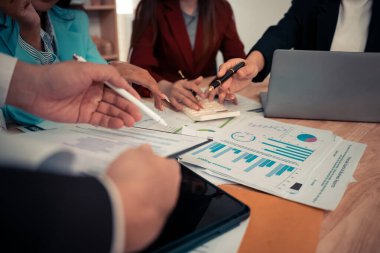 Stratejik planlama için dizüstü bilgisayarlar ve dijital çizelgeler kullanarak iş ekibiyle veri analiz toplantısı. Ofiste çalışan dijital tabletler ve iş grafikleriyle.