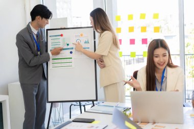 Bir grup iş adamı bir proje veya sunum üzerinde birlikte çalışarak dizüstü bilgisayar, belge ve kahve ile toplantı yapıyor veya tartışıyorlar, bir beyin fırtınası veya proje planlama faaliyeti öneriyorlar.