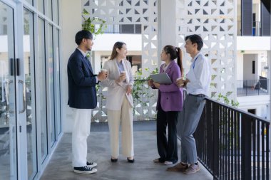 Bir grup iş adamı bir proje veya sunum üzerinde birlikte çalışarak dizüstü bilgisayar, belge ve kahve ile toplantı yapıyor veya tartışıyorlar, bir beyin fırtınası veya proje planlama faaliyeti öneriyorlar.