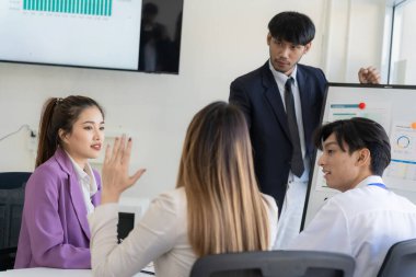 Bir grup iş adamı bir proje veya sunum üzerinde birlikte çalışarak dizüstü bilgisayar, belge ve kahve ile toplantı yapıyor veya tartışıyorlar, bir beyin fırtınası veya proje planlama faaliyeti öneriyorlar.
