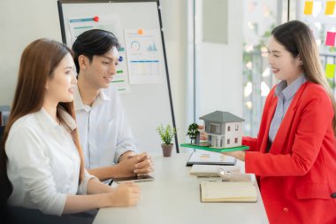 Ev satın alma sözleşmesinin imzalanmasını açıklamak yerine, banka müdürü gayrimenkul yatırım belgelerini tartışıyor ve açıklıyor..