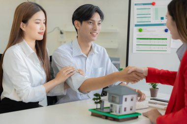 İki işadamı, masa, iş ve yatırım anlaşması, ortaklık tokalaşması, gayrimenkul anlaşması gibi ev modelleriyle el sıkışıyor..