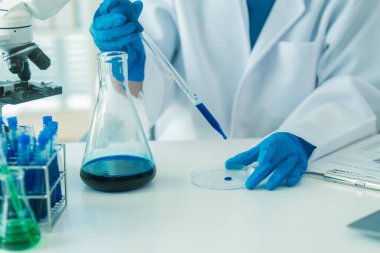 Bilim insanları modern laboratuvar tıbbi araştırmalarını kullanarak cam test tüplerindeki temiz sıvılarla deney yapıyorlar. Sağlık yeniliklerini geliştirme deneyleri.