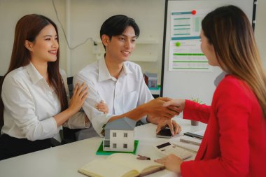 İki işadamı, masa, iş ve yatırım anlaşması, ortaklık tokalaşması, gayrimenkul anlaşması gibi ev modelleriyle el sıkışıyor..