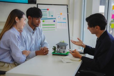 Ev satın alma sözleşmesinin imzalanmasını açıklamak yerine, banka müdürü gayrimenkul yatırım belgelerini tartışıyor ve açıklıyor..