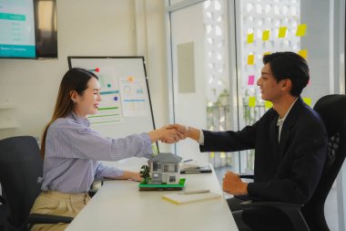 İki işadamı, masa, iş ve yatırım anlaşması, ortaklık tokalaşması, gayrimenkul anlaşması gibi ev modelleriyle el sıkışıyor..