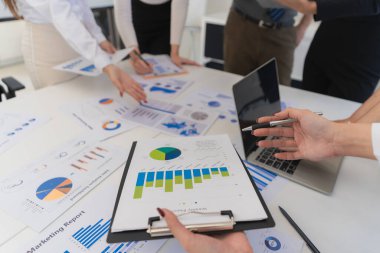 İşbirliği üzerine yoğunlaşarak, el ve teçhizat ve yazı kullanılarak yapılan iş toplantısı. Belgeleri, verileri ve vergi ücretlerini inceleyen işletme yöneticileri. Kapat..